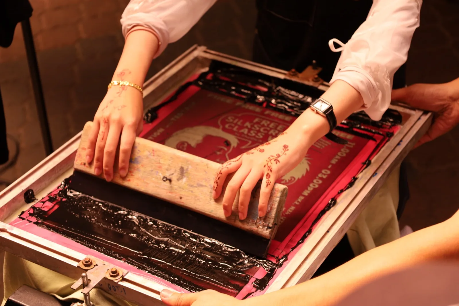 A screen-printing demonstration with a squeegee and ink at TEDxUTM in Johor Bahru