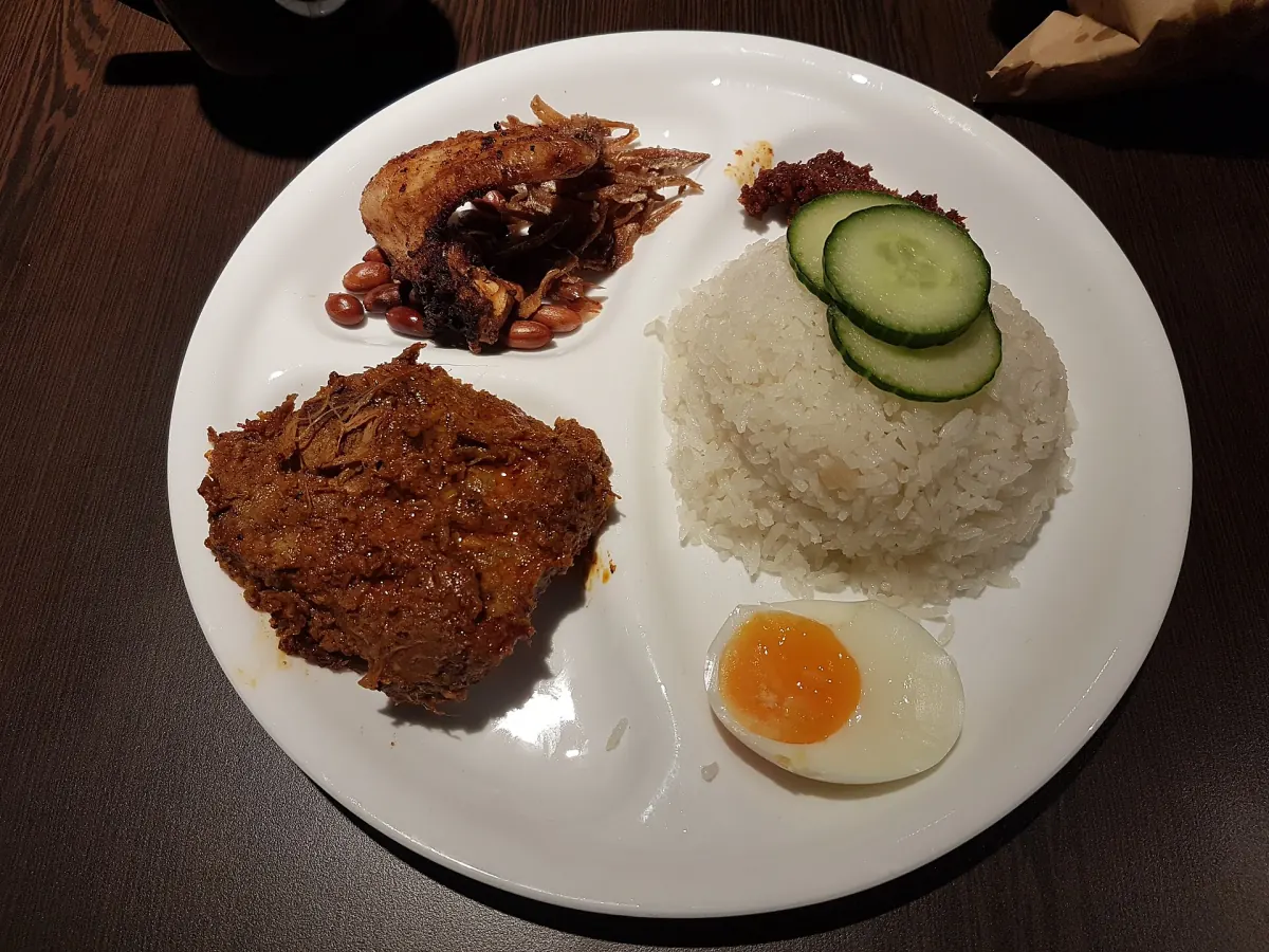 Nasi lemak with spiced chicken, coconut rice, sambal, egg, cucumber, anchovies and peanuts
